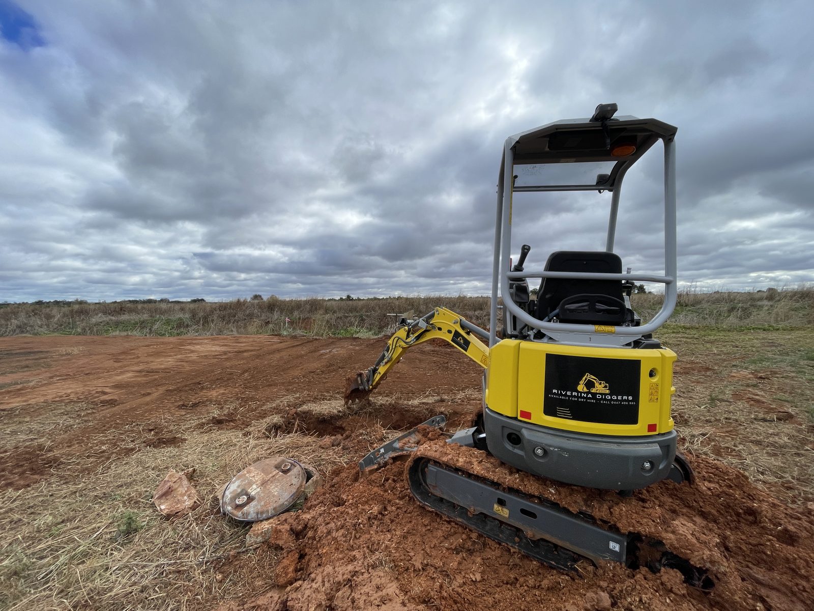 Rear of the Riverina Diggers excavator working close to a tank lid, showing zero tail swing